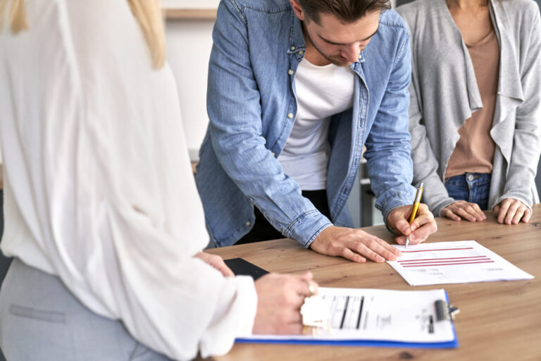 Businessman sitting at his desk signing a document